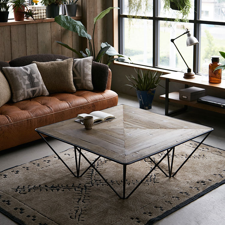 テーブルトップの木組みと幾何学的な脚部がデザインポイントのコーヒーテーブル